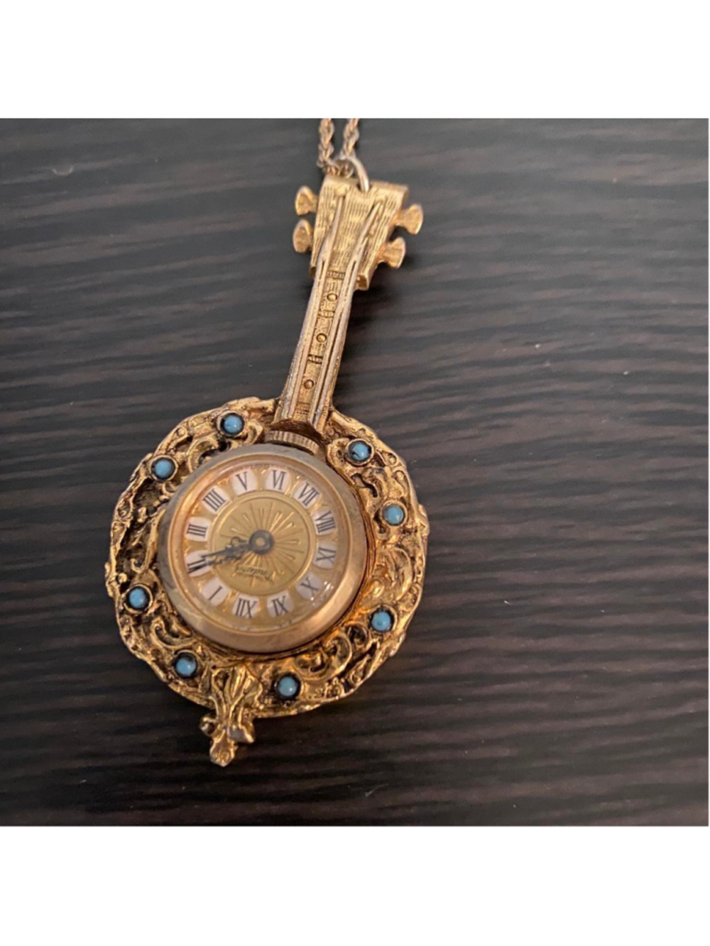 Vintage gold necklace with pendant in the shape of a violin/banjo with a clock i